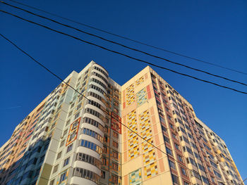 Low angle view of buildings against clear blue sky