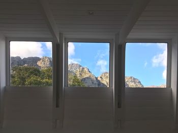 Scenic view of mountains against sky seen through window