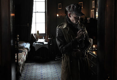 Man smoking pipe while standing at home