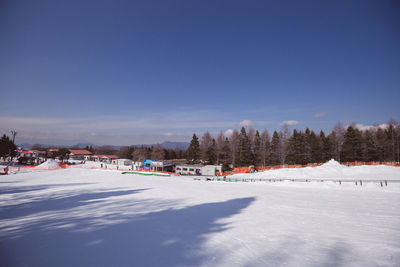 Snow covered landscape against blue sky