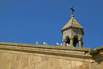 Low angle view of cross against clear blue sky