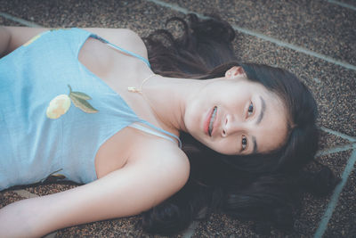 High angle portrait of smiling woman lying down