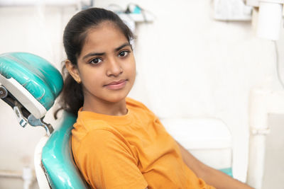 Side view of young woman sitting in bathroom