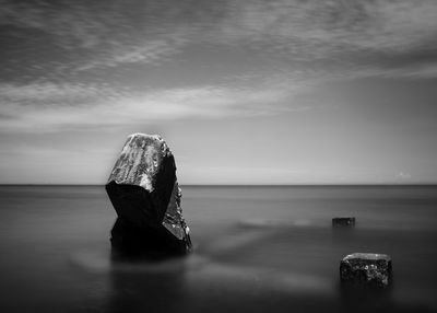 Close-up of rock in sea against sky