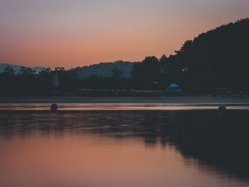 Scenic view of lake against sky at sunset