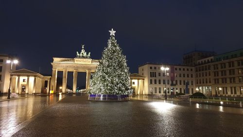 Illuminated city against sky at night