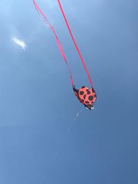 Low angle view of kite flying against clear blue sky