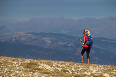 Full length of woman standing on mountain against sky