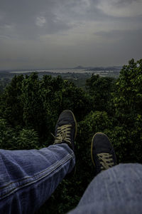 Low section of man on land against sky