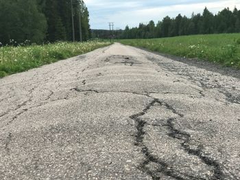 Road amidst field against sky