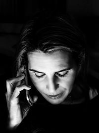 Close-up of woman talking on phone in darkroom