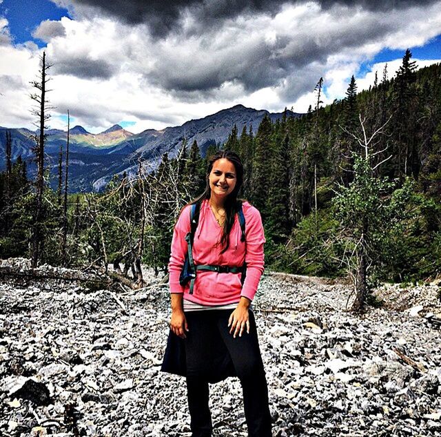 casual clothing, sky, lifestyles, looking at camera, person, portrait, leisure activity, standing, mountain, front view, young adult, smiling, cloud - sky, full length, three quarter length, happiness, nature, young women