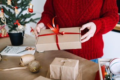 Midsection of woman using mobile phone on table