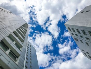 Low angle view of modern building against cloudy sky