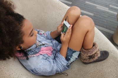 Girl sitting with cell phone and headphones