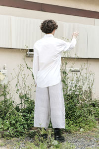 Rear view of man standing by wall