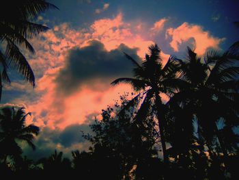 Low angle view of silhouette palm trees against romantic sky