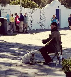 People sitting on dog against sky