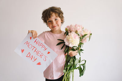 Happy mothers day. cheerful happy child with peonys bouquet.