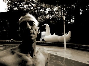 Close-up of shirtless man relaxing in swimming pool