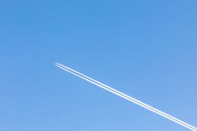 Low angle view of vapor trail against blue sky