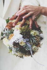 Close-up of newlywed couple holding bouquet