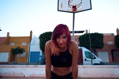 Portrait of beautiful woman standing against sky