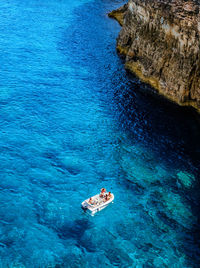 High angle view of people on rock in sea