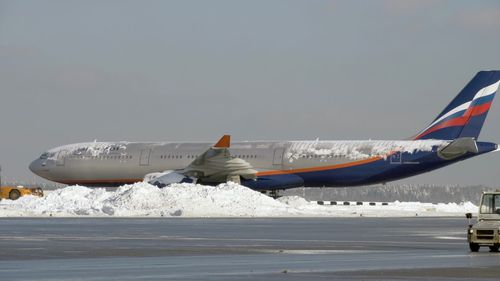 Airplane on runway against clear sky during winter