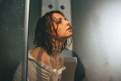 Thoughtful woman sitting in bathroom