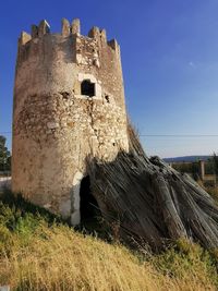 Low angle view of old building against blue sky