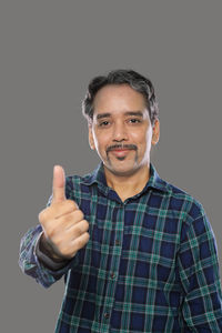 Portrait of man standing against black background