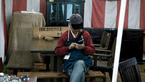 Man using mobile phone while sitting on bench