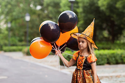 Portrait of young woman holding balloons