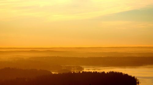 Scenic view of silhouette landscape against orange sky