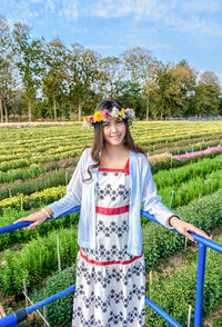 Portrait of smiling young woman standing on field