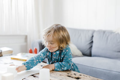 Cute girl playing on table in living room at home