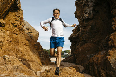 Low angle view of man standing on rock