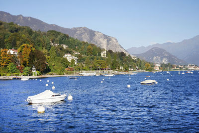 Scenic view of sea by mountains against blue sky