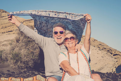 Portrait of happy friends standing on beach