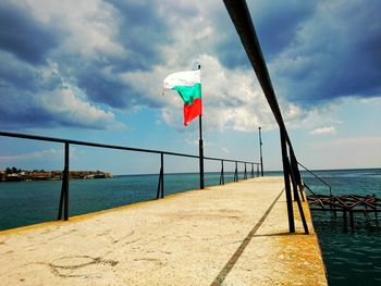 Lifeguard flag on sea against sky