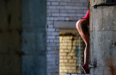 Side view of woman against red wall