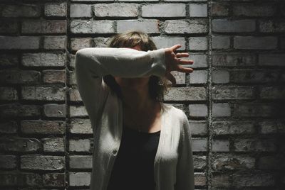 Woman standing against brick wall