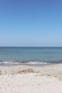 Scenic view of beach against clear blue sky