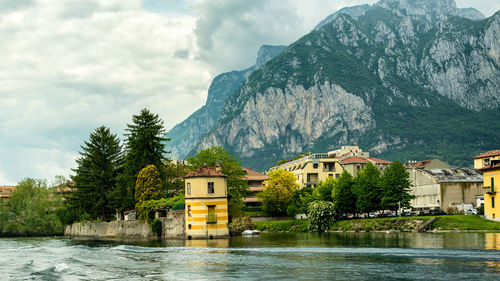 Houses by trees and buildings against sky