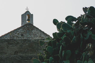 Low angle view of cross on building against sky