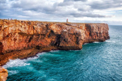 Rock formations by sea against sky