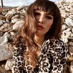 Portrait of young woman against rocks