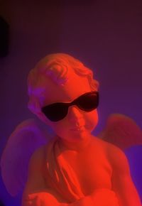 Close-up portrait of boy wearing sunglasses against gray background