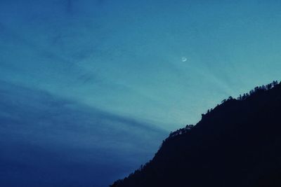 Low angle view of silhouette mountain against sky at night